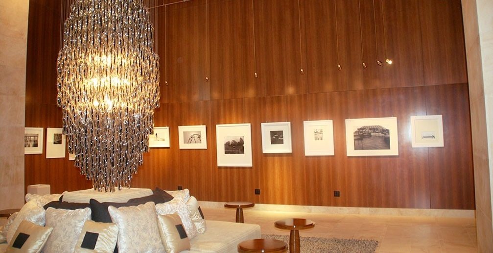 Un salon du casino Borgata : murs de bois toute hauteur, lustre de verre, photographies encadrées, canapé couvert de coussins satinés