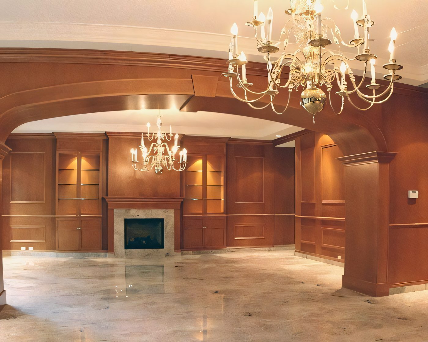 Une salle entièrement lambrissée de bois : arche, foyer de marbre, lustres de laiton