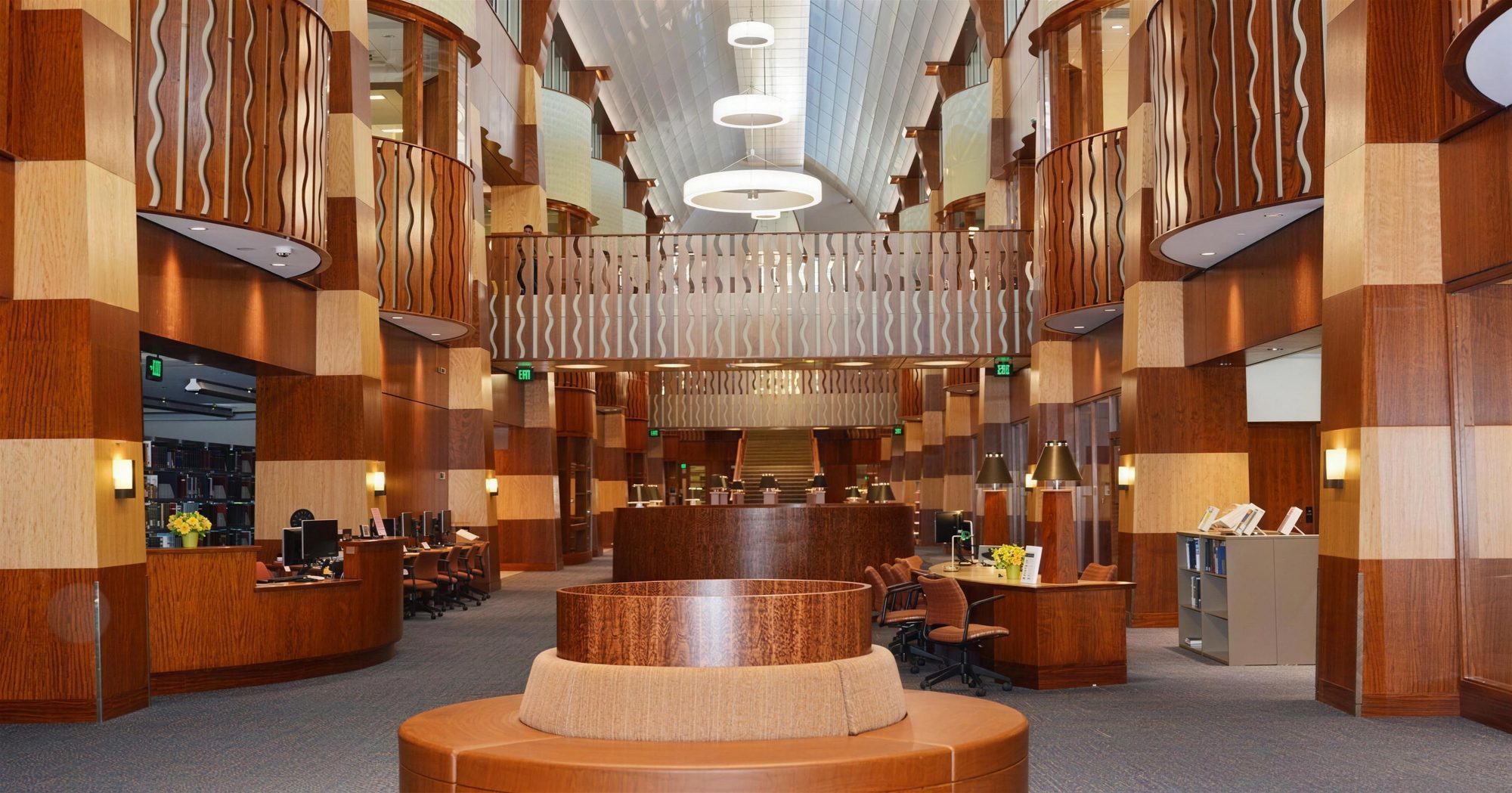 L’atrium de la bibliothèque de l’Université Quinnipiac : colonnes et garde-corps en bois, comptoir circulaire